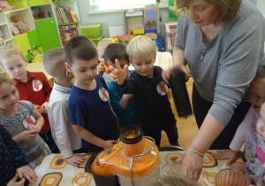 Przedszkolaki przyglądaja się jak działa sokowirówka